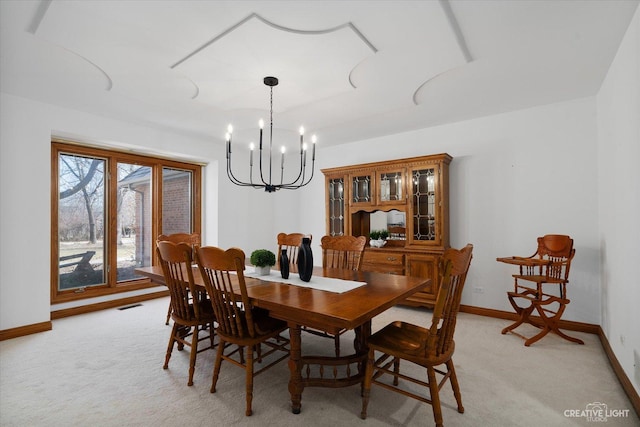 dining room with an inviting chandelier, light colored carpet, visible vents, and baseboards