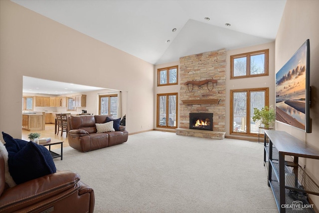 living room with high vaulted ceiling, a fireplace, a wealth of natural light, and light carpet