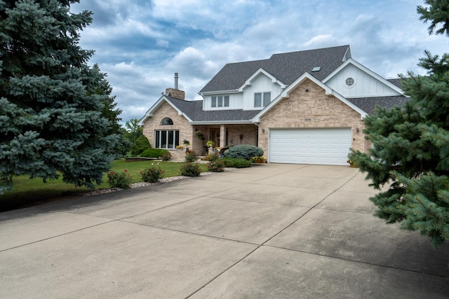 traditional-style home featuring a front yard, driveway, roof with shingles, an attached garage, and brick siding