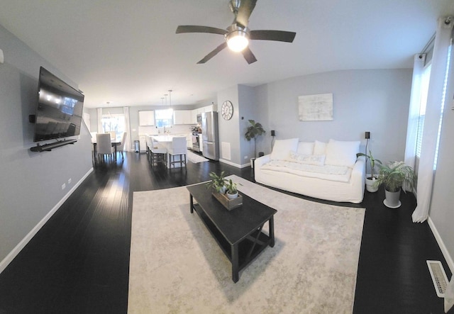 living area featuring visible vents, dark wood-style floors, baseboards, and ceiling fan