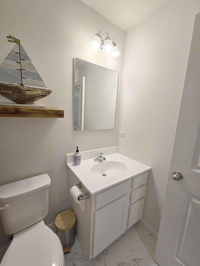 bathroom with toilet, marble finish floor, and vanity