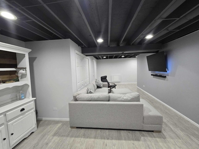 living area featuring baseboards and light wood finished floors