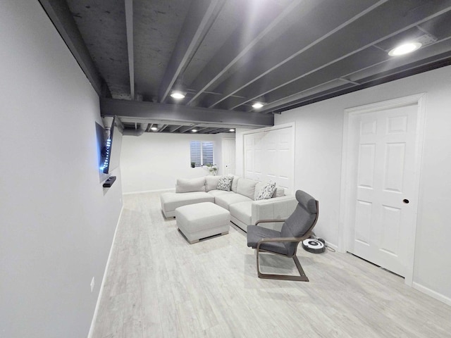 living area with baseboards and wood finished floors