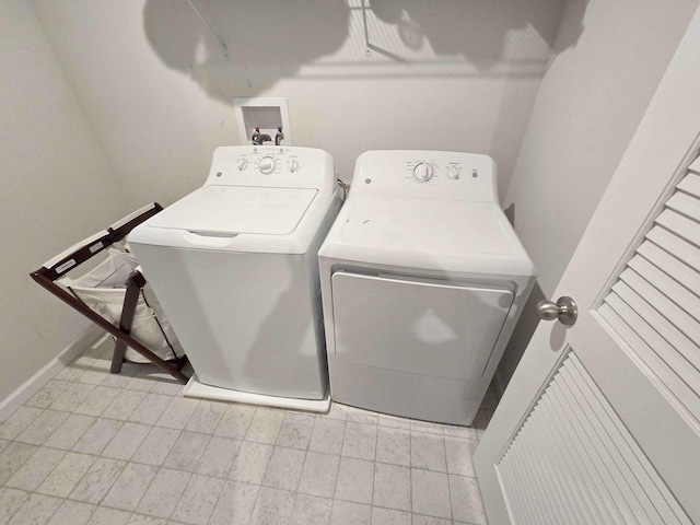 laundry area with washing machine and clothes dryer, laundry area, and baseboards