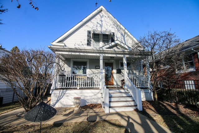 view of front of property with a porch and fence