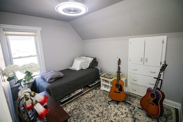 bedroom featuring baseboards and lofted ceiling