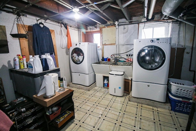 laundry room with laundry area, a wealth of natural light, washing machine and dryer, and tile patterned floors