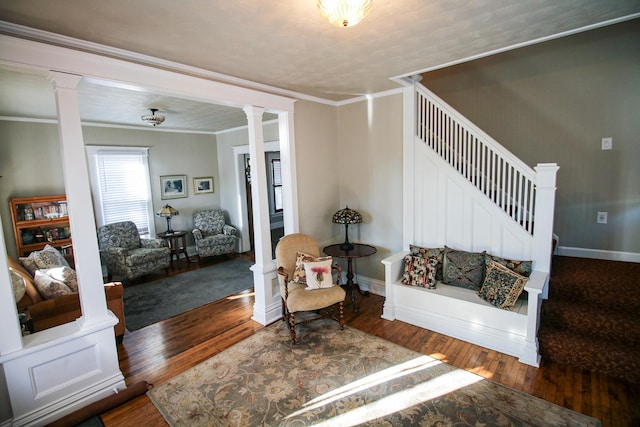 living room with decorative columns, hardwood / wood-style floors, stairs, and ornamental molding