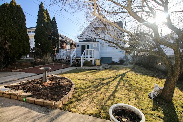 view of front of property with a deck, a front lawn, and fence