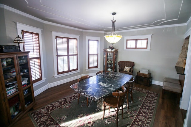 dining area featuring wood finished floors, baseboards, and ornamental molding