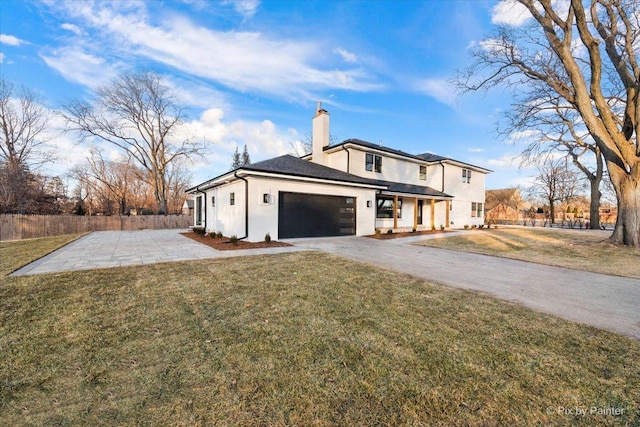 view of front of house featuring a front lawn, fence, a chimney, a garage, and driveway