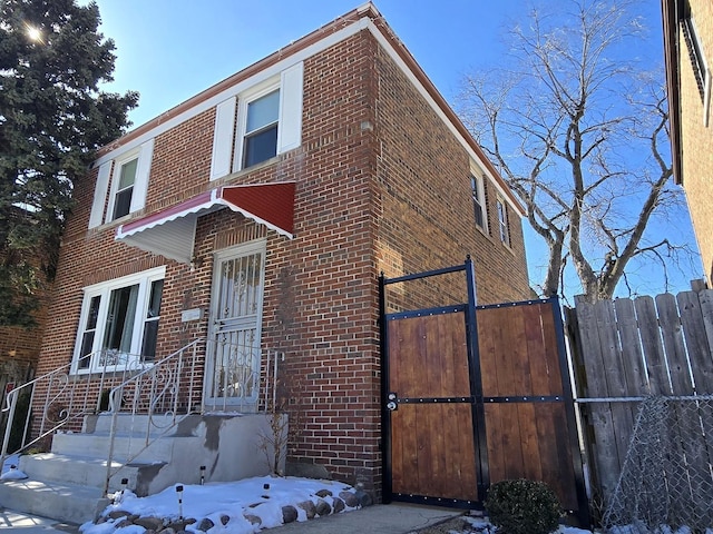 view of front facade featuring fence and brick siding