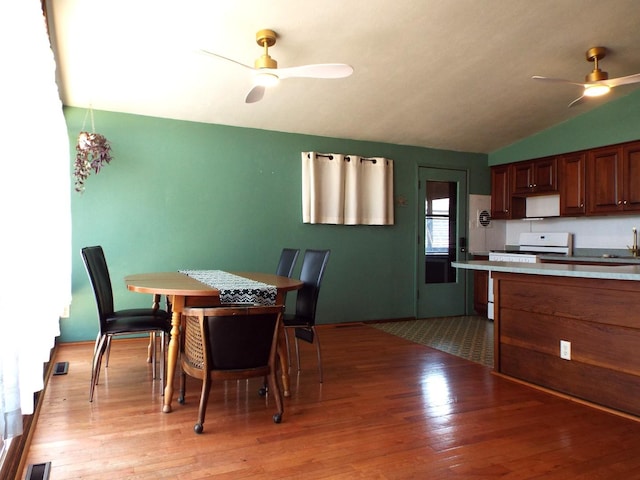 dining room with visible vents, lofted ceiling, light wood-style flooring, and a ceiling fan