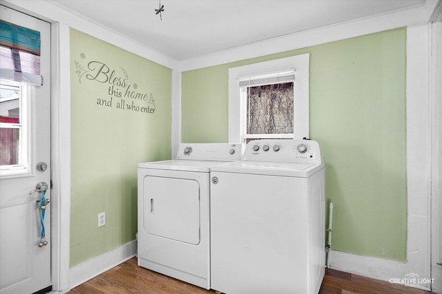 clothes washing area featuring laundry area, plenty of natural light, separate washer and dryer, and wood finished floors