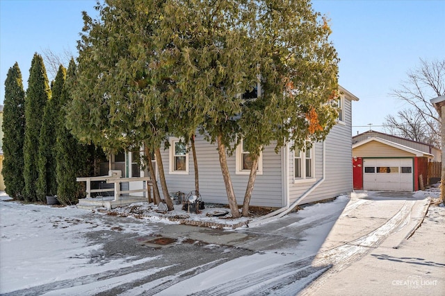 view of property hidden behind natural elements with an outdoor structure, concrete driveway, and a detached garage