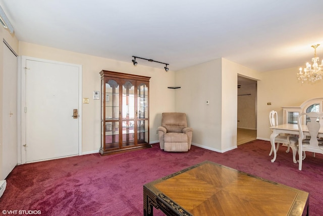 carpeted living room featuring rail lighting, a notable chandelier, baseboards, and baseboard heating