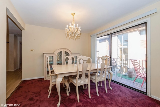 dining space featuring a notable chandelier, baseboards, and dark colored carpet