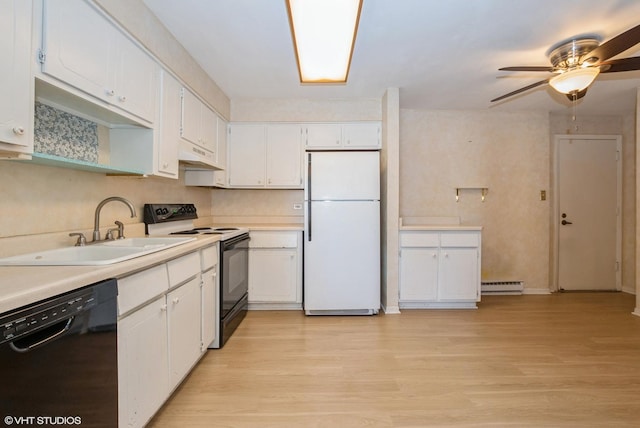 kitchen with a sink, a baseboard heating unit, black appliances, and light wood-style flooring