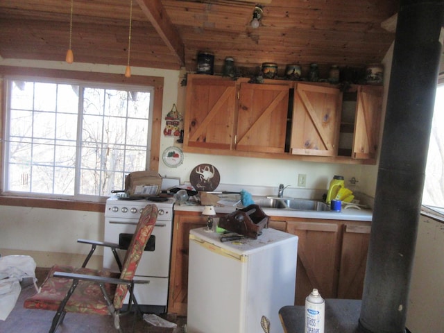 kitchen featuring plenty of natural light, light countertops, white range with gas stovetop, and a sink