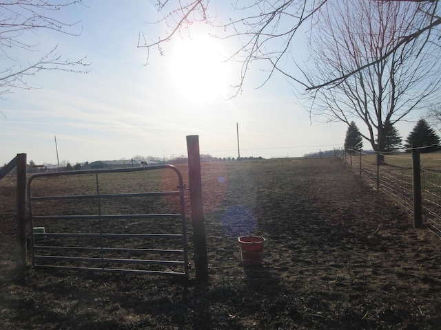 view of gate featuring a rural view and fence