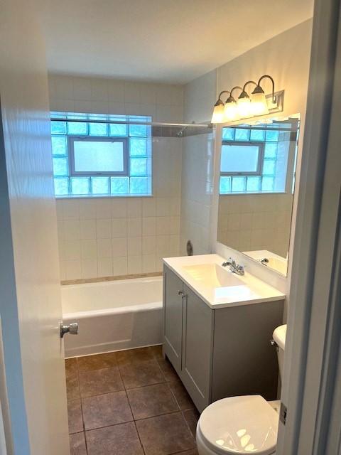 full bath featuring tile patterned flooring, toilet, vanity, and shower / tub combination