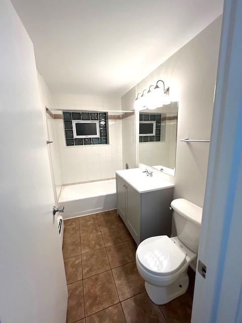 bathroom featuring tile patterned flooring, toilet, vanity, and shower / tub combination