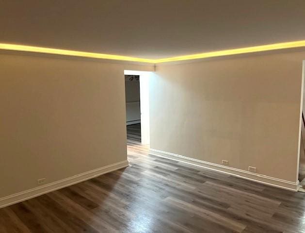 empty room with dark wood finished floors and baseboards