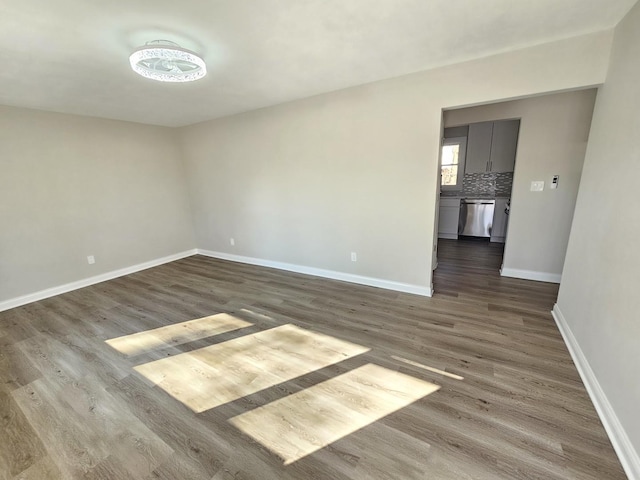 empty room with baseboards and wood finished floors