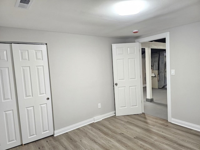 unfurnished bedroom featuring visible vents, baseboards, and light wood-style flooring