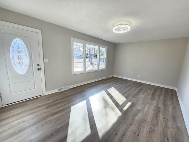 entrance foyer featuring visible vents, baseboards, and wood finished floors