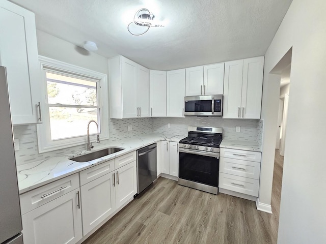 kitchen with a sink, appliances with stainless steel finishes, and white cabinetry