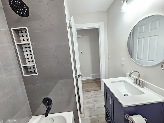 full bath featuring vanity, tub / shower combination, visible vents, and wood finish floors