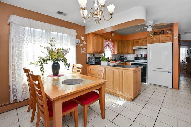 kitchen with visible vents, under cabinet range hood, freestanding refrigerator, light tile patterned floors, and gas range