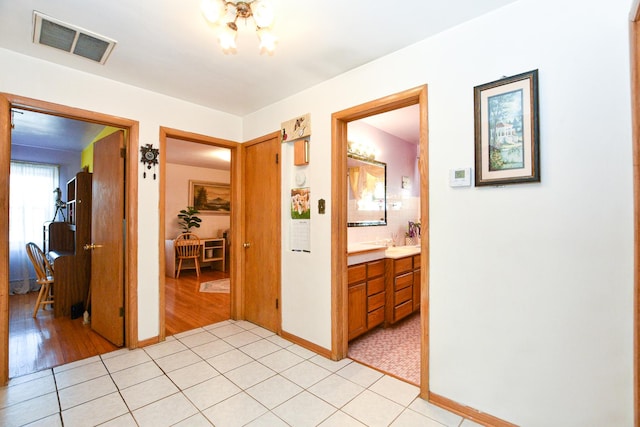 hallway with light tile patterned floors and visible vents