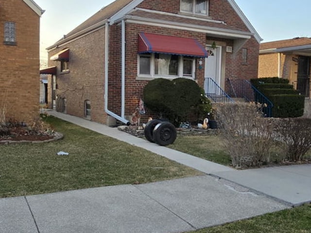 view of front of house featuring brick siding and a front yard