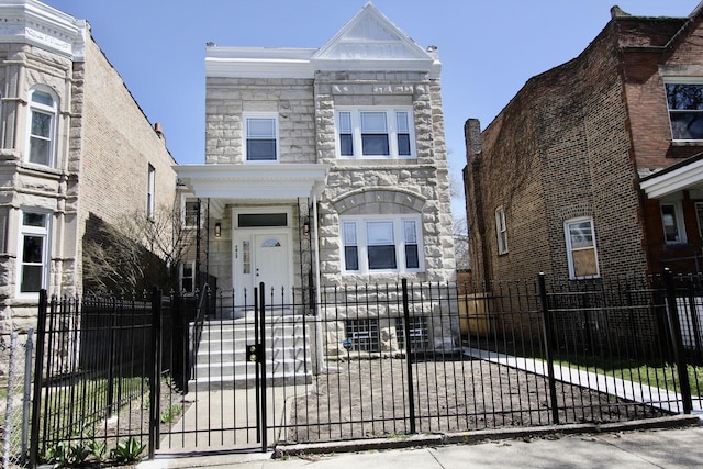 view of front of property with a fenced front yard and stone siding