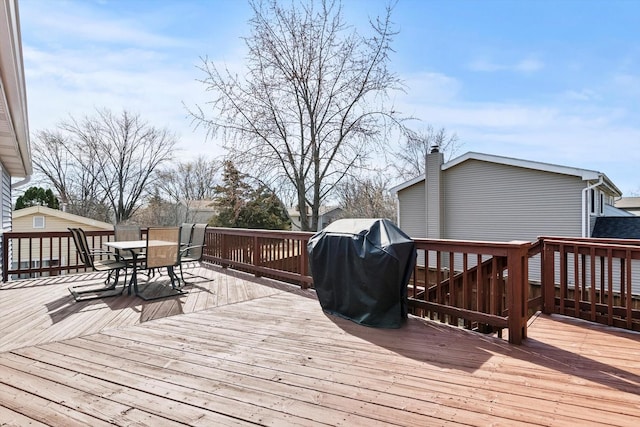 wooden terrace with grilling area and outdoor dining area