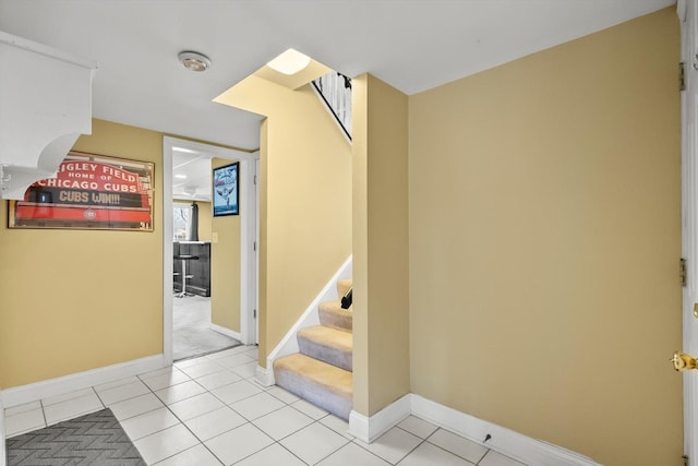 staircase featuring tile patterned flooring and baseboards