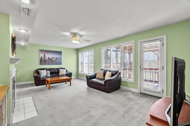 living room with visible vents, light colored carpet, baseboards, and ceiling fan