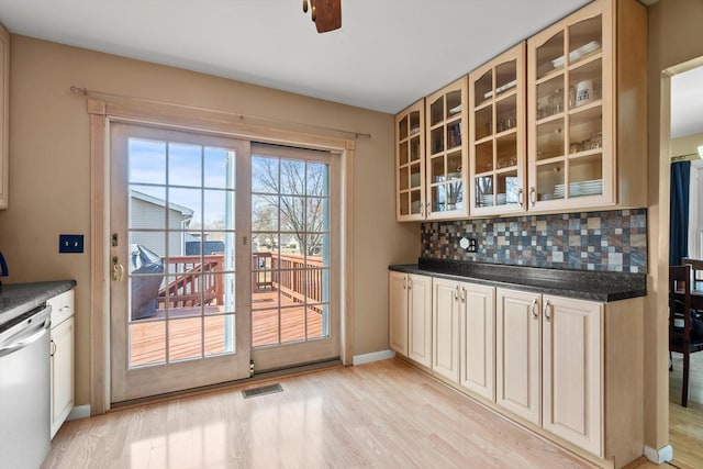 bar with visible vents, backsplash, dishwasher, and light wood-type flooring