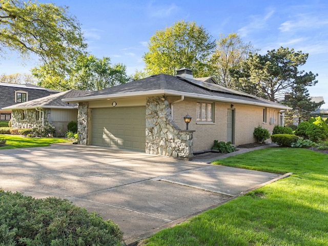 41 Mockingbird Ln, Oak Brook, IL 60523 - view of side of home featuring a garage, a yard, a chimney, roof mounted solar panels, and concrete driveway