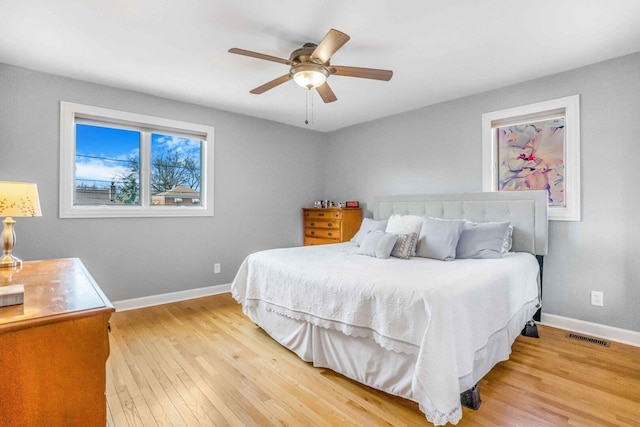 bedroom with visible vents, baseboards, ceiling fan, and light wood finished floors