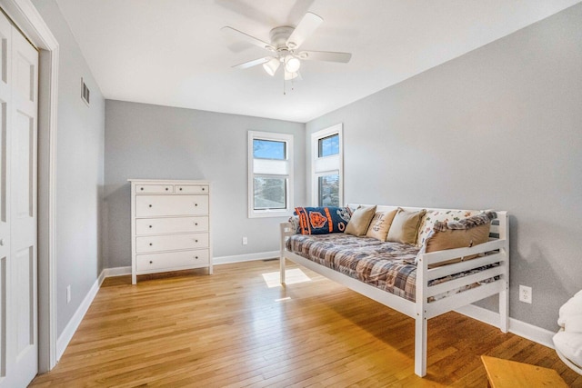 living area with visible vents, a ceiling fan, baseboards, and light wood finished floors