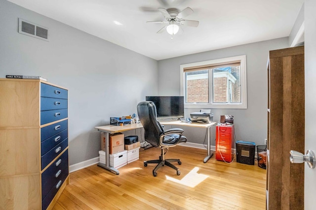 office area featuring light wood-style flooring, baseboards, visible vents, and ceiling fan