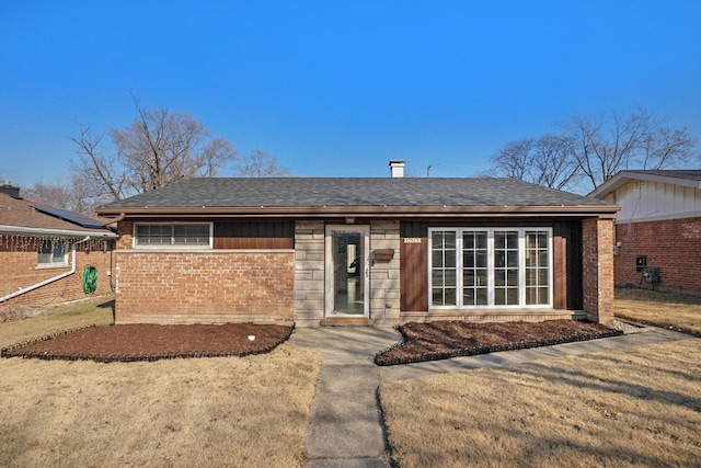 ranch-style home featuring brick siding and a shingled roof