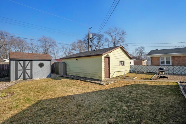 view of yard with a storage unit, an outbuilding, and fence