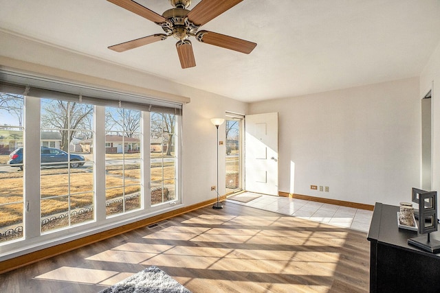 sunroom / solarium with visible vents and a ceiling fan