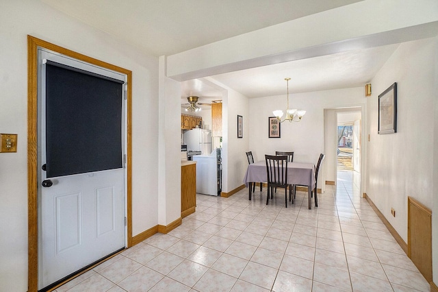 dining area with light tile patterned floors, ceiling fan with notable chandelier, and baseboards