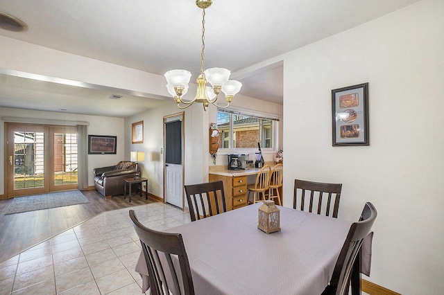 tiled dining area with visible vents, baseboards, and a chandelier