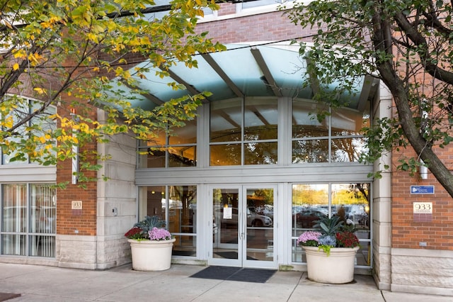 view of exterior entry featuring brick siding and french doors